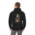 A man stands wearing a black hoodie with a graphic of a skeleton in a cowboy outfit smoking a cigar and holding a bag of money, with a stack of bitcoin coins on the back side of the hoodie.