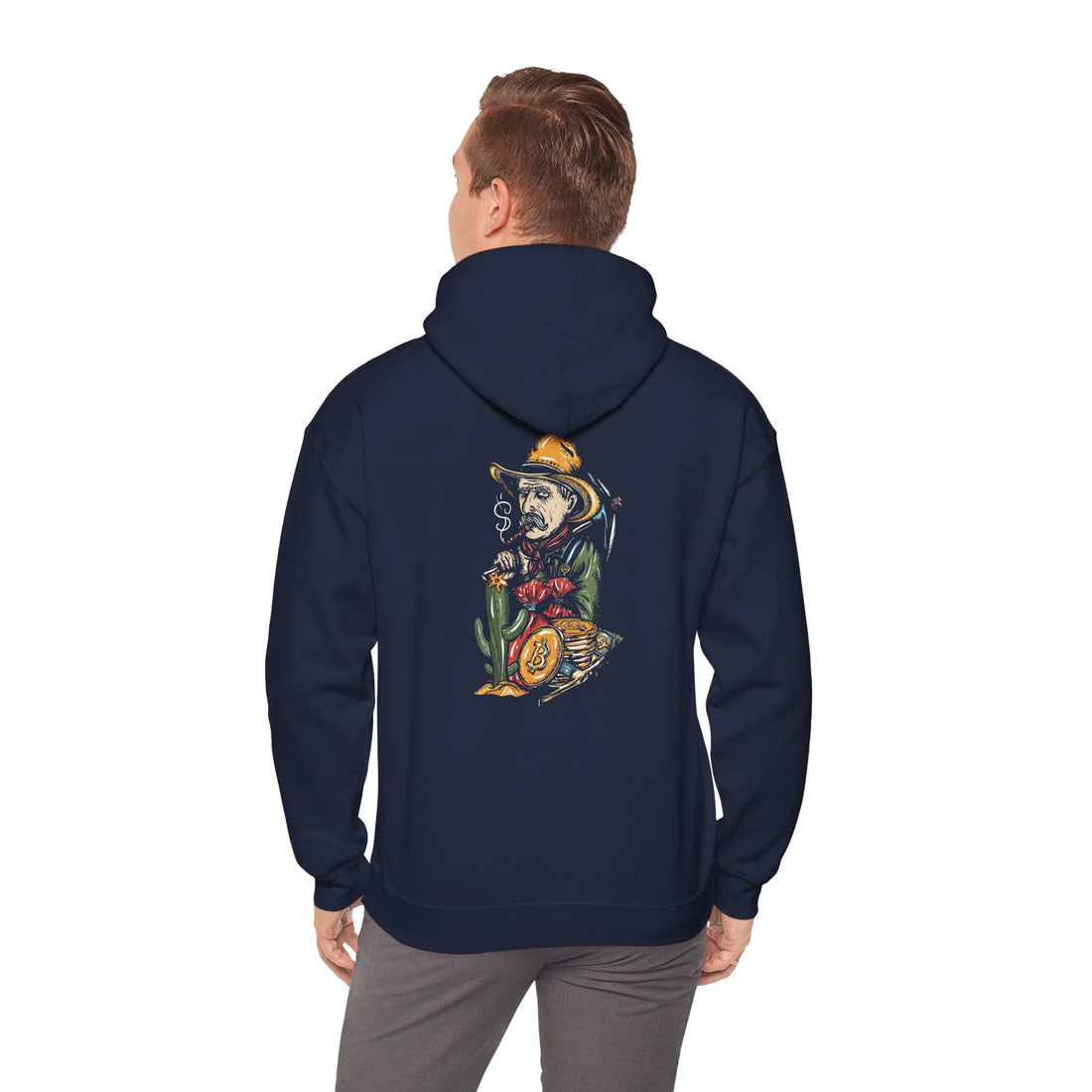 A man stands wearing a navy blue hoodie with a graphic of a skeleton in a cowboy outfit smoking a cigar and holding a bag of money, with a stack of bitcoin coins on the back side of the hoodie.